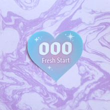 Load image into Gallery viewer, Heart-shaped sticker with '000 Fresh Start' text on a marbled purple and white background
