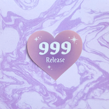 Load image into Gallery viewer, Purple gradient heart-shaped sticker with '999 Release' white text on a purple and white marbled background.
